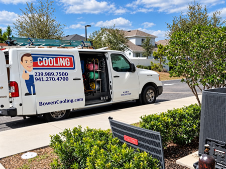 HVAC technician inspecting an outdoor AC unit in Fort Myers, FL